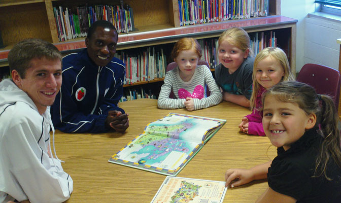 Georgia Regents runner Jaiden Brandt (left) and assistant coach Pardon Ndhlovu pose with students at Pasadena Park Elementary during Thursday's community engagement activities.